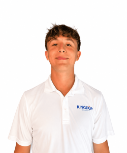 Young man in a white polo shirt with "KINGDOM" logo, standing and looking at the camera against a plain white background.