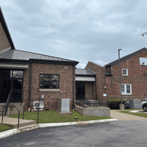 Exterior of a brick commercial or institutional building complex on an overcast day.